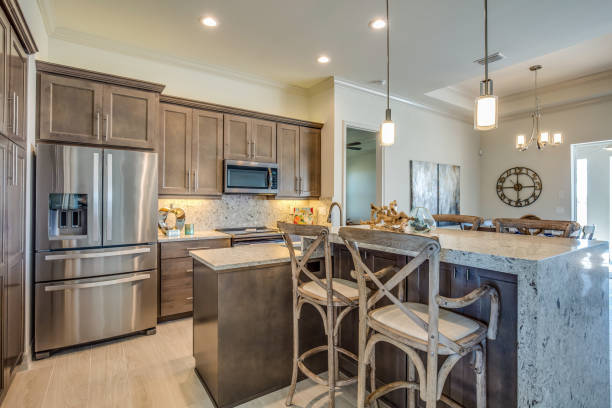 Beautiful kitchen with brown cabinets Quartz waterfall island for dining domestic kitchen cabinet elegance showcase interior stock pictures, royalty-free photos & images