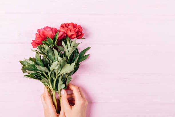 istock Top view female hands with manicure holding bouquet 1249289228