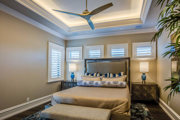 istock Classy bedroom with tray ceiling and shutters on windows 1249289935