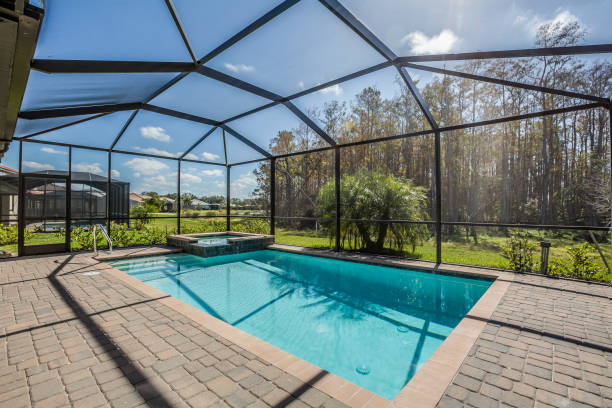 swimming pool and net enclosure in back of home - recinto cercado imagens e fotografias de stock