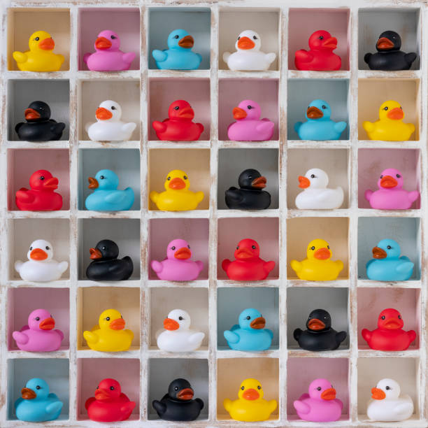 istock Many different vibrant multi-colored rubber ducks in white wood pigeon hole compartments. 1249290861