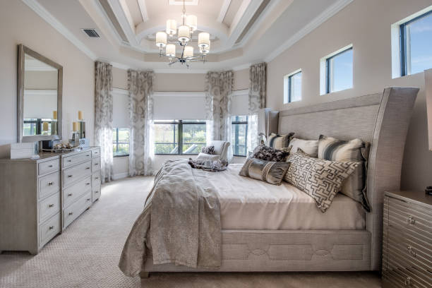 Beautiful bedroom with gray furniture Many luxuries such as chandelier, coffered ceiling and reading nook in master bedroom owners bedroom photos stock pictures, royalty-free photos & images