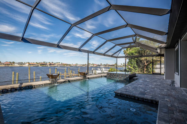 istock Swimming pool and net enclosure in back of home 1249291034