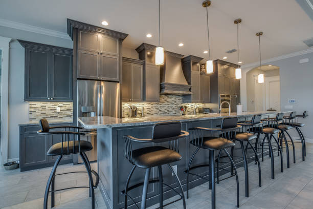 Dark gray cabinets and pendant lights adorn this classy kitchen Enough island seating for a large family bar stool photos stock pictures, royalty-free photos & images