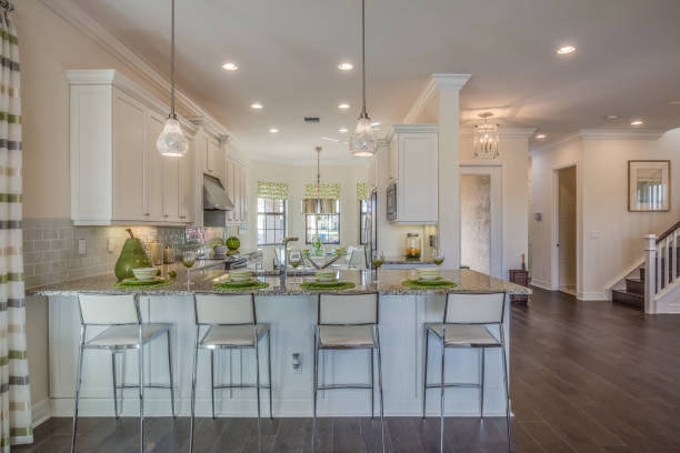 Beautiful white kitchen in new build Four metal kitchen stools for easy dining florida real estate house home interior stock pictures, royalty-free photos & images