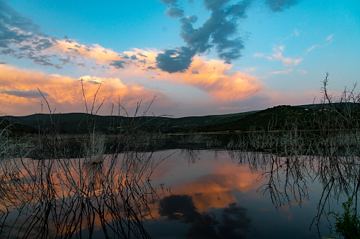 lake and nature landscape at sunset. dramatic clouds are reflected in the lake