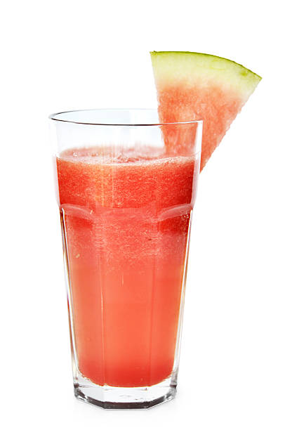 Tall glass of red smoothie with watermelon slice Watermelon smoothie garnished with watermelon slices  isolated on white watermelon juice stock pictures, royalty-free photos & images