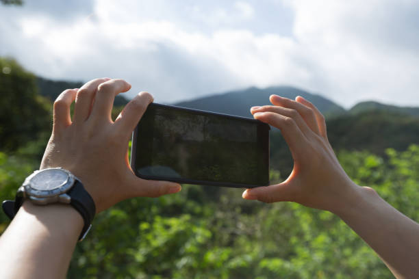 istock Hands using smartphone taking picture in summer nature 1249307545