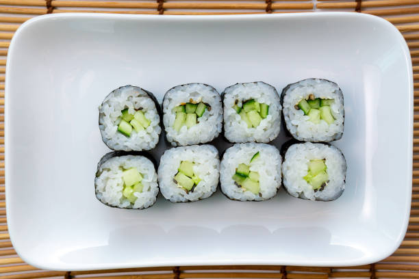 istock Kappa Maki Classic roll with cucumber. Hosomaki thin rolls, small rolls, with cucumber. top view on a white plate. 1249308912