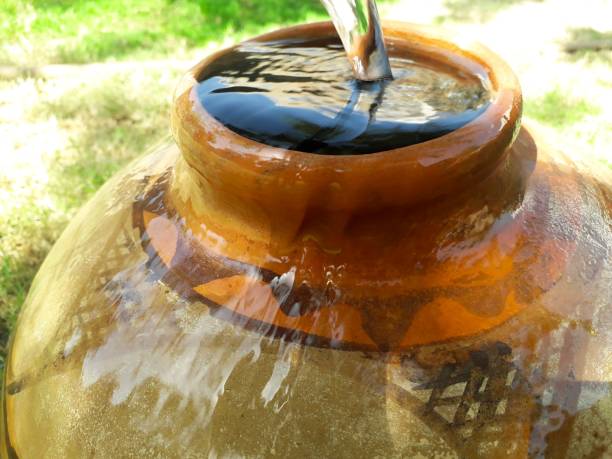 Large raindrops fall into a barrel of water. Blurred background, out of focus