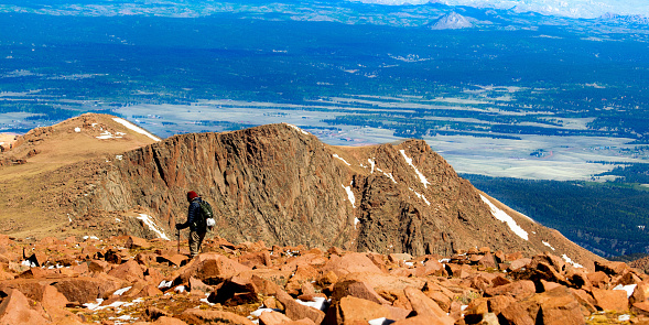 A lone hiker treks across Devil’s Playground atop Pike’s Peak - the highest point in the Colorado Rocky Mountains.
