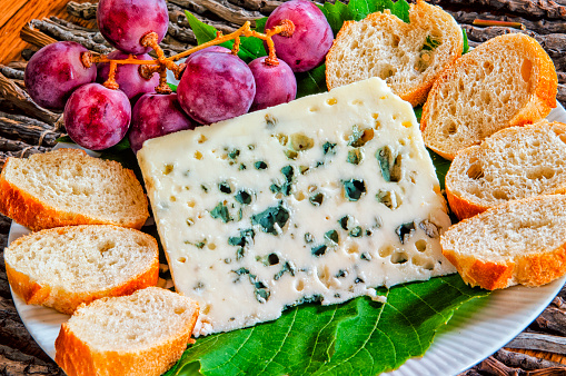 Cheese platter for an appetizer with Roquefort, which is  a sheep milk cheese from Southern France, and is one of the world's best known blue cheeses. Only those cheeses aged in the natural Combalou caves of Roquefort-sur-Soulzon may bear the name Roquefort, as it is a recognised geographical indication, or has a protected designation of origin.