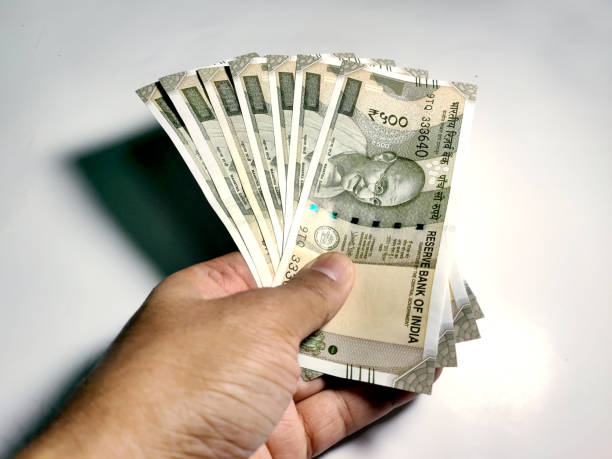 istock Hand holding five hundred Indian rupee notes against white background 1249320777