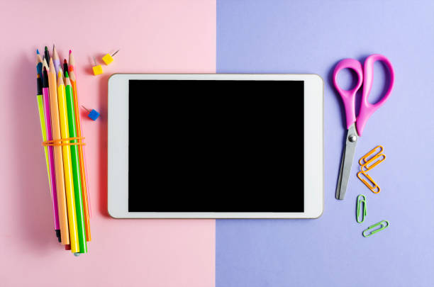 istock A tablet with an empty screen and office supplies on a colored background. Concept app for school children or online learning for children. Copy space 1249321546