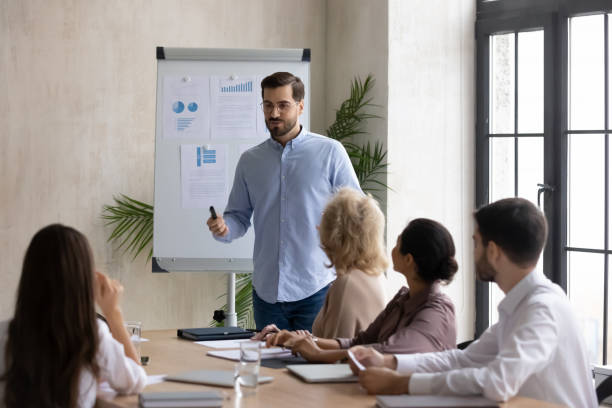 Confident handsome businessman flip charts presentation new project in boardroom.