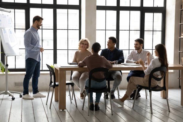 istock Smiling businessman waiting for decision from diverse colleagues on presentation. 1249323438