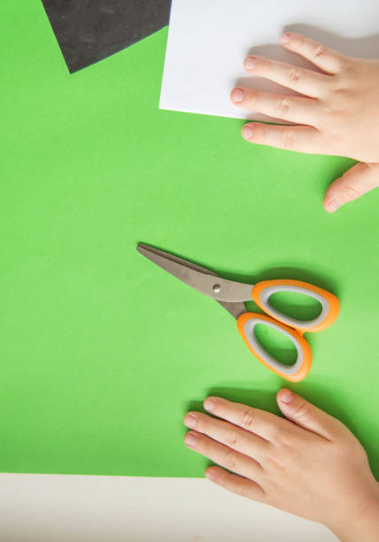 istock Top view of children's hands on colored paper sheets, colored cardboard and scissors for children's creativity 1249324285