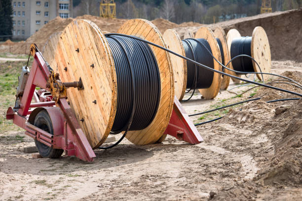 istock Concept of electricity supply for construction projects. Several wooden coils with power cable laid in trench. 1249326582