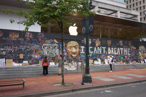 Boarded Up Apple Portland Store With Protest Murals Portland, OR, USA - Jun 12, 2020: Passers-by stop and take a look at the boarded-up Apple Store in downtown Portland's Pioneer Place, which has become unofficial canvases for peaceful protest. Artists have also joined to promote peace over violence. portland oregon photos stock pictures, royalty-free photos & images
