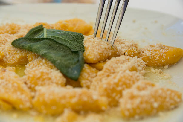 Pumpkin Gnocchi with Parmesan cheese and a decorative sage leaf stock photo
