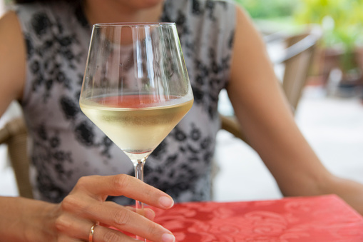 Glass of Chardonnay, Sauvignon or Rkatsiteli white wine over outdoors background 
