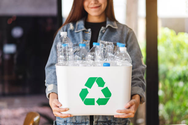 istock A woman collecting and holding a recyclable garbage plastic bottles in a trash bin 1249333384