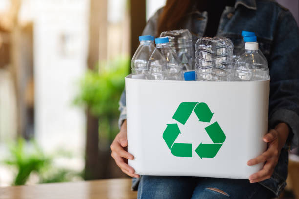 istock A woman collecting and holding a recyclable garbage plastic bottles in a trash bin 1249333450