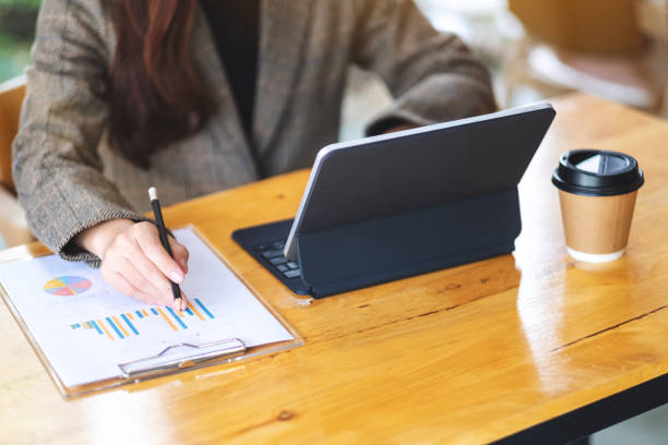 istock a businesswoman working and using digital tablet as a computer pc with financial document on the table 1249333451
