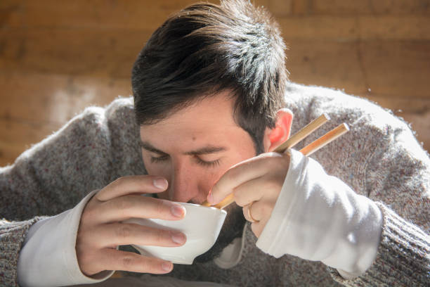 Portrait of a bearded man seating and eating from a bowl
