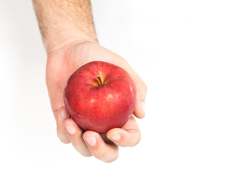 Manzana roja fresca con la mano aislada sobre fondo blanco photo
