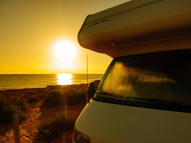 istock Camper car on beach at sunrise 1249338498