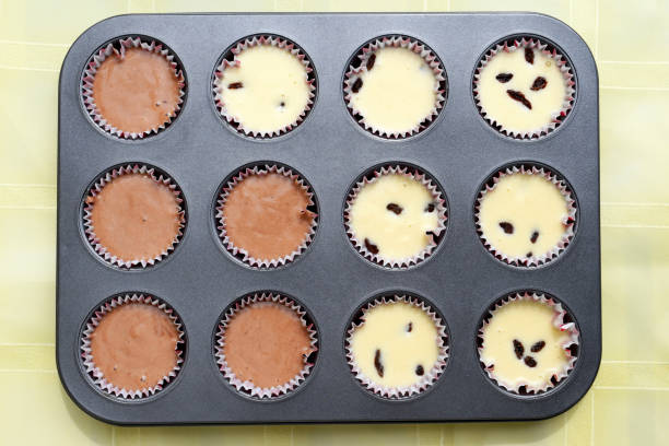 istock Baking tray with paper moulds filled with muffin dough, ready for baking 1249341690