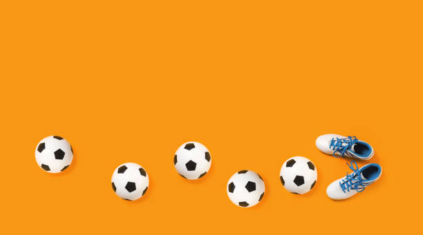 istock Soccer balls and cleats on orange background 1249341833