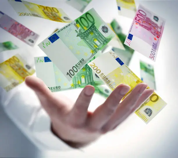 Male hand with flying 100 Euro notes