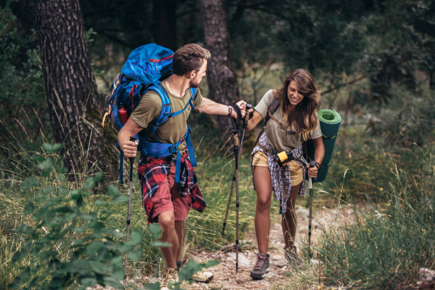 istock Backpackers couple hiking during fall with sticks 1249343556