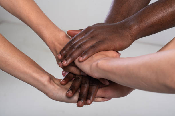 Anti racist studio shot of unrecognizable group of people holding hands Anti racist, anti discrimination studio shot of  unrecognizable, mixed race three people holding hands together. social justice concept photos stock pictures, royalty-free photos & images