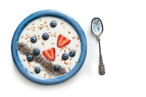 Homemade yogurt blue bowl healthy breakfast with chia strawberries blackberries isolated on white background