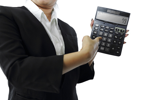 Young female finance professional in formal wear holding a calculator.