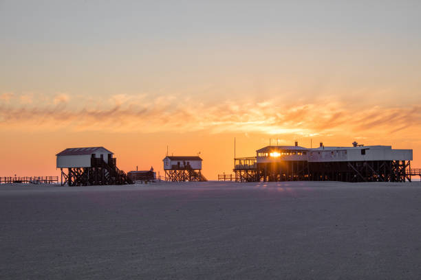 The stunning beach of St. Peter-Ording. This beach is located at the west coast of Schleswig-Holstein and is said to be the widest beach in Europe. In front a huge pile dwelling with restrooms and life rescue service. 50 Mpx image taken with Canon EOS 5Ds .