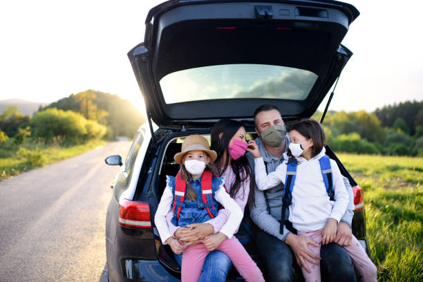 istock Family with two small daughters on trip outdoors in nature, wearing face masks. 1249347315