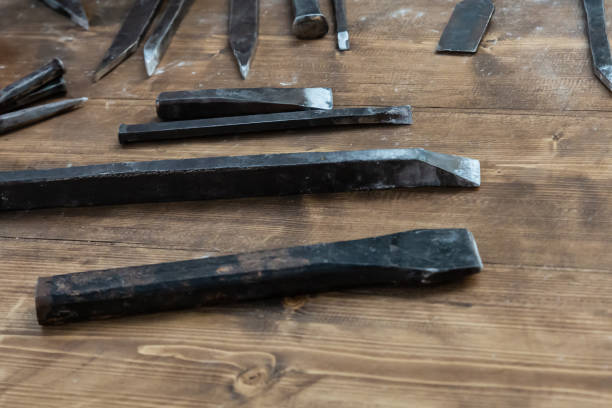 set of iron chisels sharp mason tool lies on a wooden table to create a pattern on the sculpture - table toughness steel pattern imagens e fotografias de stock