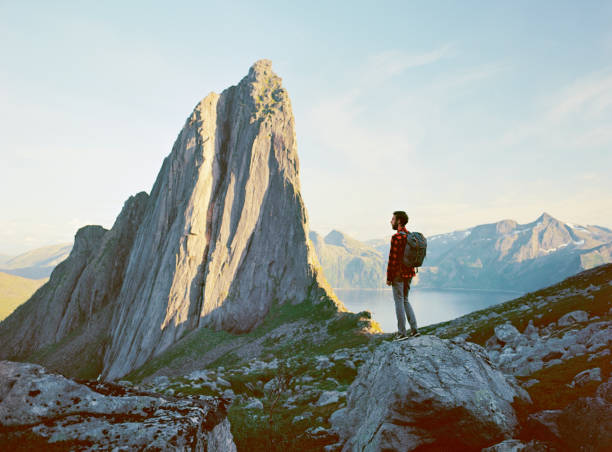 Man standing and looking at Segla  near  mountain on Senja island Young Caucasian man  standing and looking at Segla  mountain on Senja island senja island photos stock pictures, royalty-free photos & images