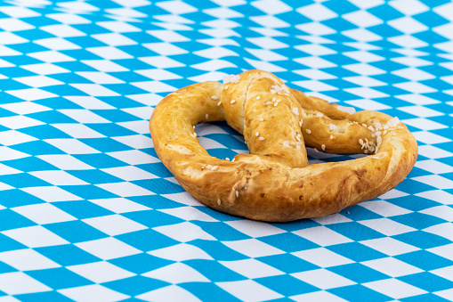 big and tasty pretzel snack for beer on a background pattern Beer Fest blue and white rhombus