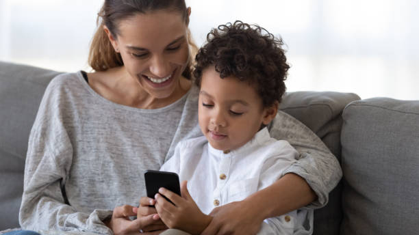 istock Loving mom relax with biracial son using cellphone 1249348548