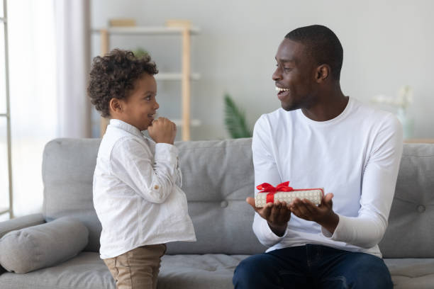 istock Little biracial boy present gift box to excited dad 1249348567