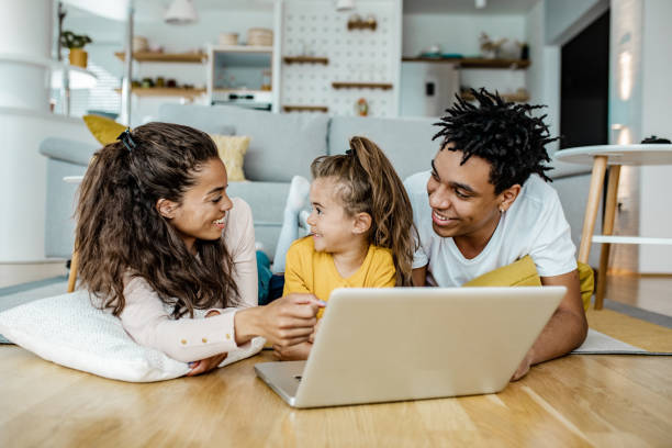 istock Parents and their daughter are using laptop at home 1249349635