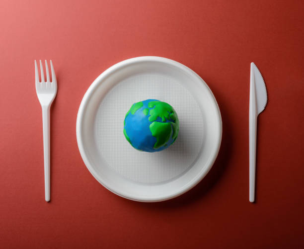 istock Serving table with Earth planet, plastic plate, fork and knife. Ecology Concept for Earth Hour, Earth Day, Ocean Day and other ECO dates. 1249349689