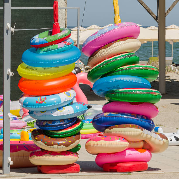 anneaux de natation colorés à vendre dans un magasin de plage - toy umbrella photos et images de collection