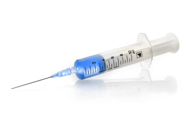 Syringe with blue vaccine Medical syringe with vaccine isolated on white background medical injection photos stock pictures, royalty-free photos & images