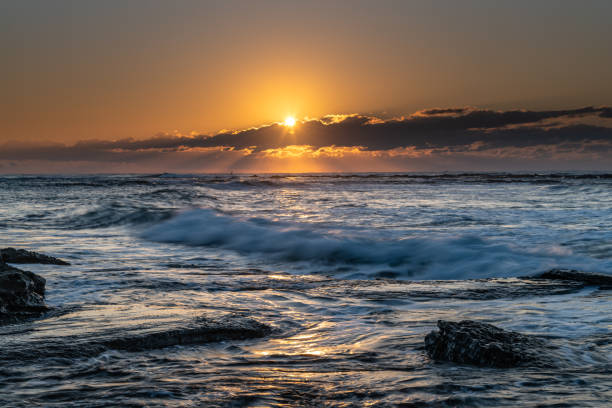 istock Sunrise Seascape with a sunburt through the low cloud bank 1249355539